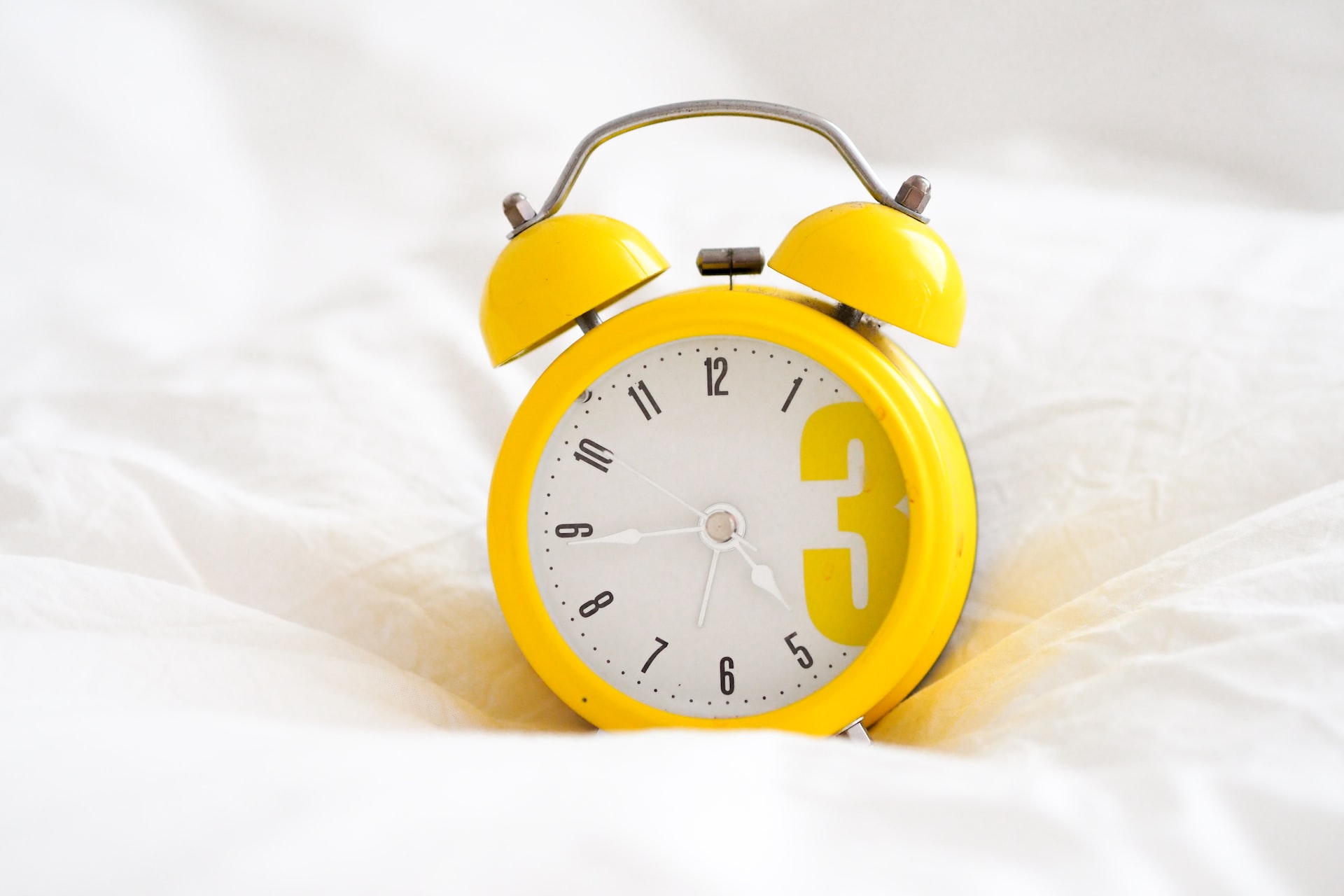 A yellow alarm clock helping someone stick to a sleep schedule