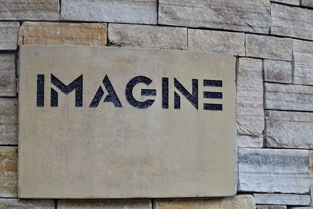 The word imagine on a brick wall