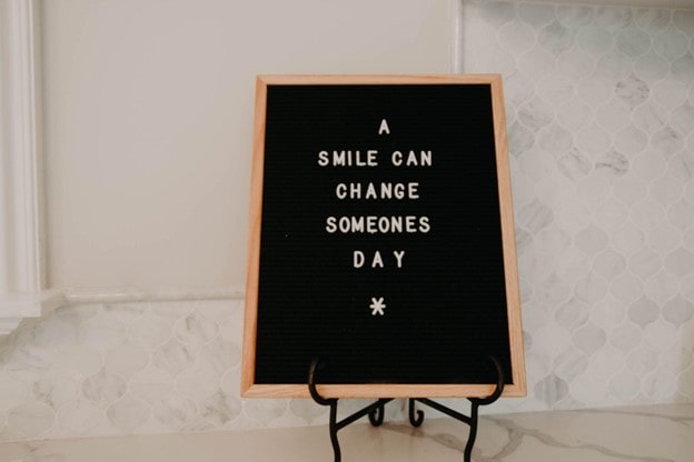 the words 'a smile can change someones day' on a mini blackboard