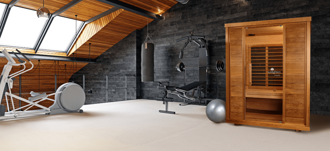 A modern home gym with a variety of exercise equipment and an infrared sauna prominently featured which highlights a holistic approach to ending inflammation through infrared sauna therapy