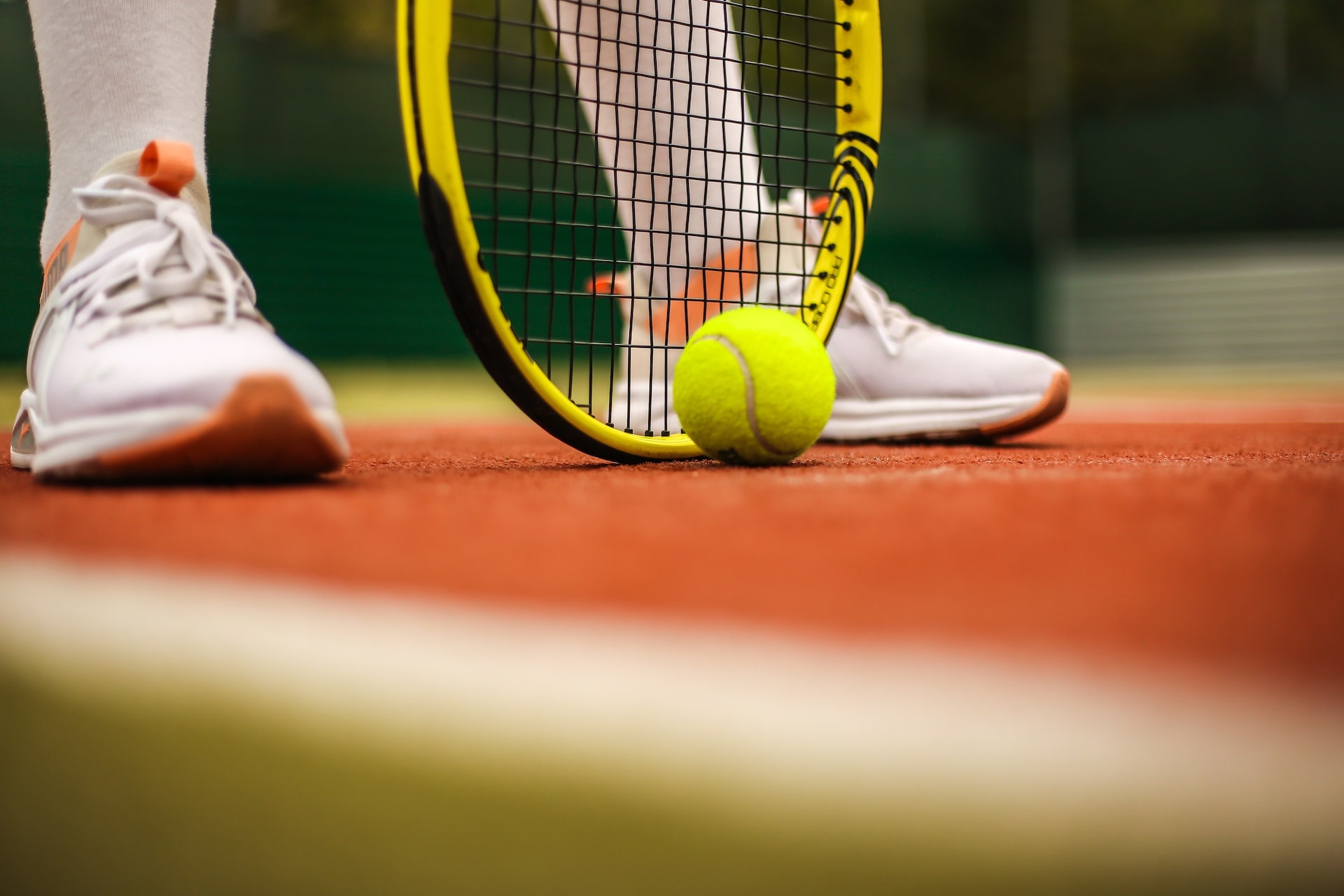 A close up of a woman's shoes while she plays tennis after managing her sports injury with cryotherapy