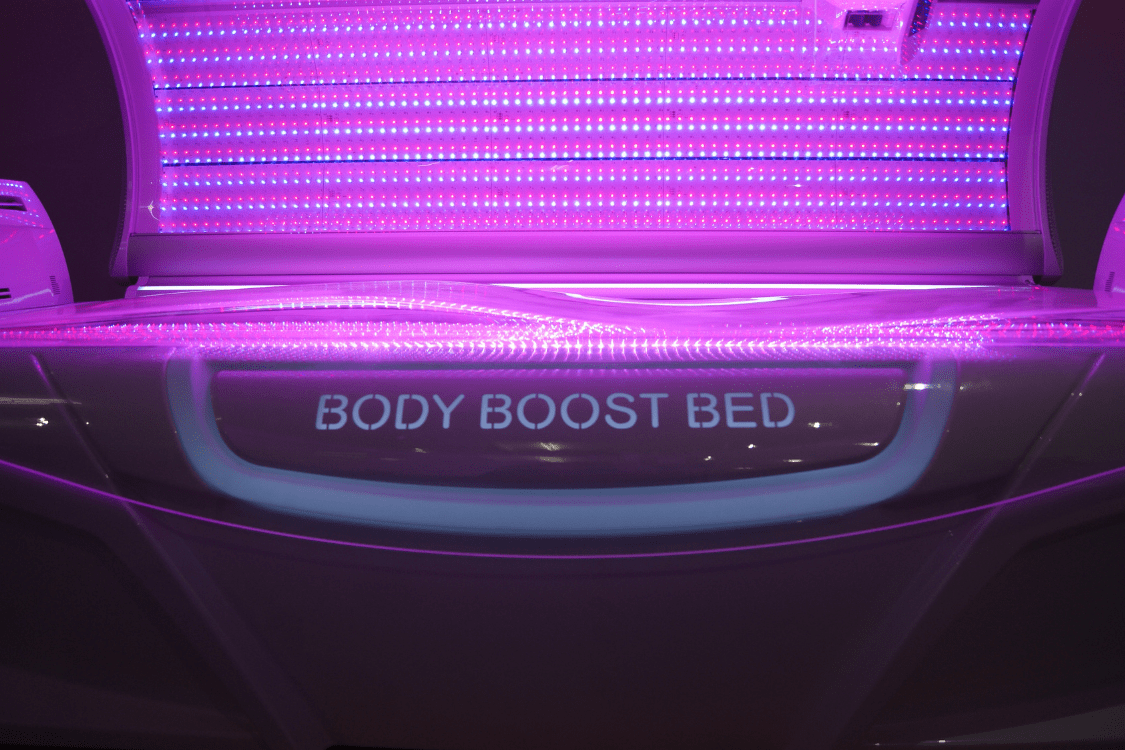 The interior of a 'Body Boost Bed' used for red light therapy, featuring rows of glowing purple lights, indicative of a treatment modality for conditions such as Lyme disease.