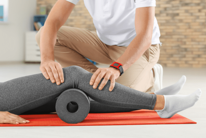 Health professional performing a rudimentary type of compression therapy on a patient during a physiotherapy session